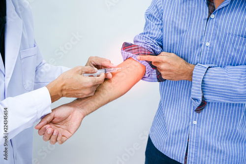 Close up of male doctor's hands making an injection to patient's arm. Healthcare and medicine concept.