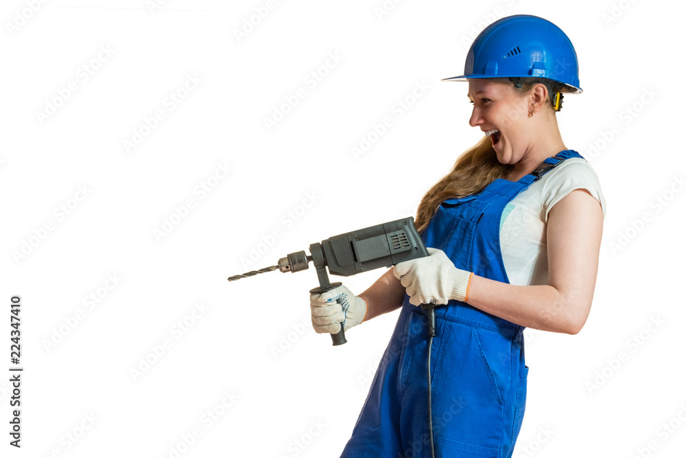 Girl in overalls with a drill in her hands. Girl in overalls with a drill in her hands.