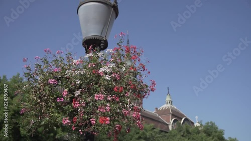 footage of lamp with flowers and building photo