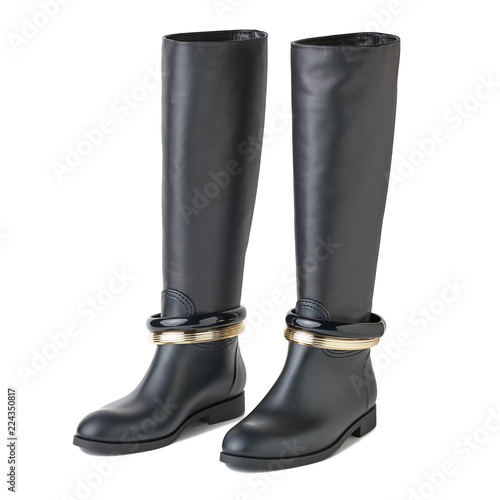 Women black leather long boots with black and golden bracelets on them. White background