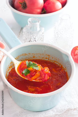 tomato sauce with vegetables in an enamel ladle, selective focus
