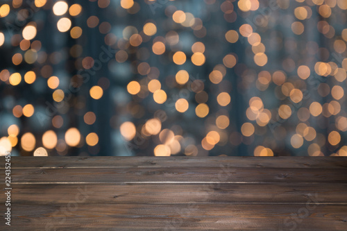 Blurred gold garland and wooden tabletop as foreground. Image for display or montage your christmas products. photo