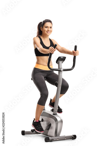 Young female riding a stationary bike