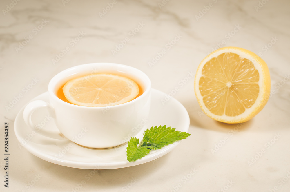 herbal tea with a lemon and mint/herbal tea with a lemon and mint on a white marble background. Selective focus herbal tea with a lemon and mint/herbal tea with a lemon and mint on a white marble background. Selective focus