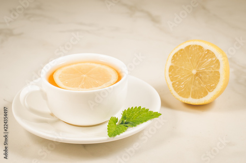 herbal tea with a lemon and mint/herbal tea with a lemon and mint on a white marble background. Selective focus