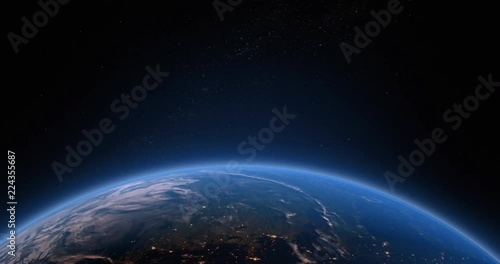 Earths atmosphere as viewed from space with the suns light starting to rise as the earth rotates.