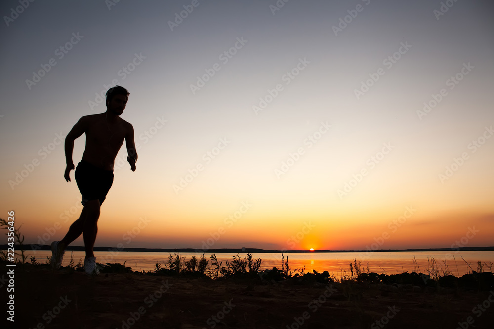 Running man silhouette in sunset time. Sport and active life concept.