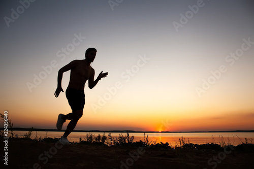 Running man silhouette in sunset time. Sport and active life concept.