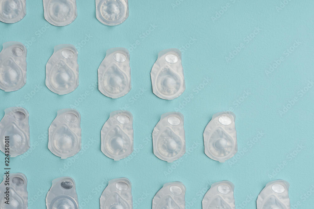 full frame of contact lenses in containers arranged on blue background full frame of contact lenses in containers arranged on blue background