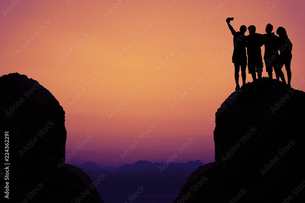 Silhouette of a group taking selfie in mountains as symbol for friendship
