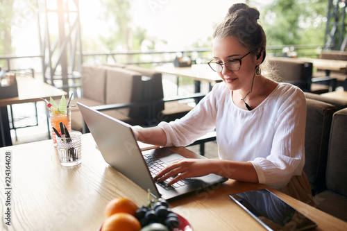 Fotografi Businesswoman working remotely at cafe with headset and laptop