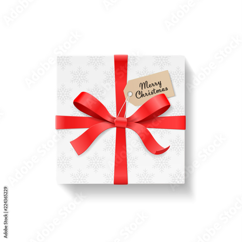 Square gift box, red color bow knot and ribbon with kraft hang tag. Snowflake pattern paper. Merry Christmas text. Happy New Year package concept. Closeup Vector illustration 3d top view