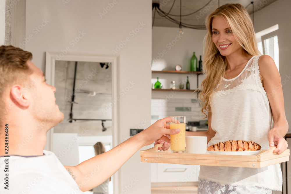 smiling woman brought breakfast in bed for boyfriend at home in morning smiling woman brought breakfast in bed for boyfriend at home in morning