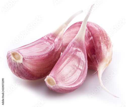 Unpeeled garlic cloves on white background.