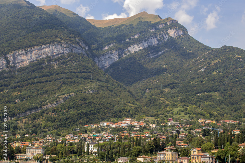 View from Lake Como to a small town at the foot of the Alpine hills, Italy.