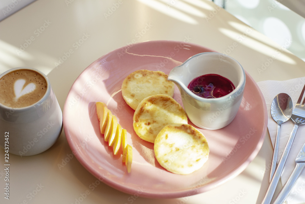 Breakfast in the cafe cheesecakes with fruit and coffee, hard light Breakfast in the cafe cheesecakes with fruit and coffee, hard light