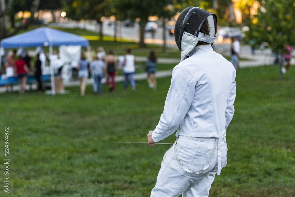 Fencing athlete on a green field Fencing athlete on a green field