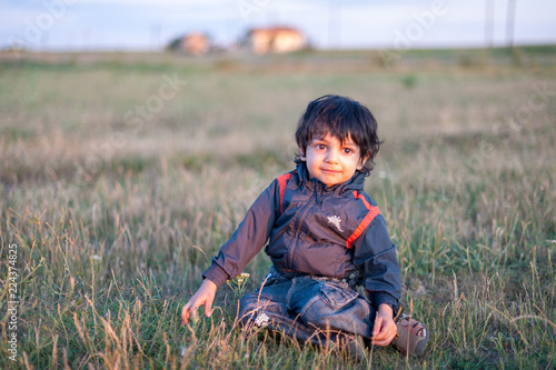 Little boy playing on field in evening light