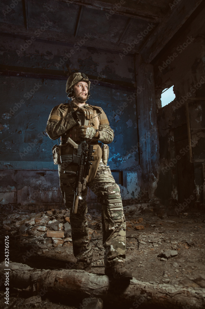 Fototapeta premium the people in uniform with weapons in the ruins