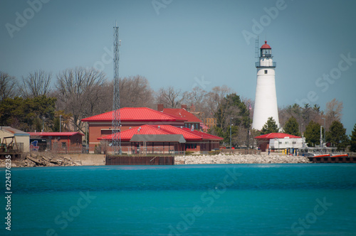 Lighthouse on the coast of lake with blue water photo