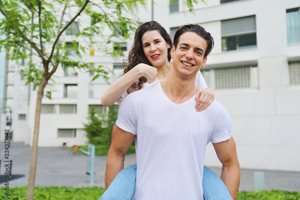 Handsome man giving piggyback to woman Handsome man giving piggyback to woman