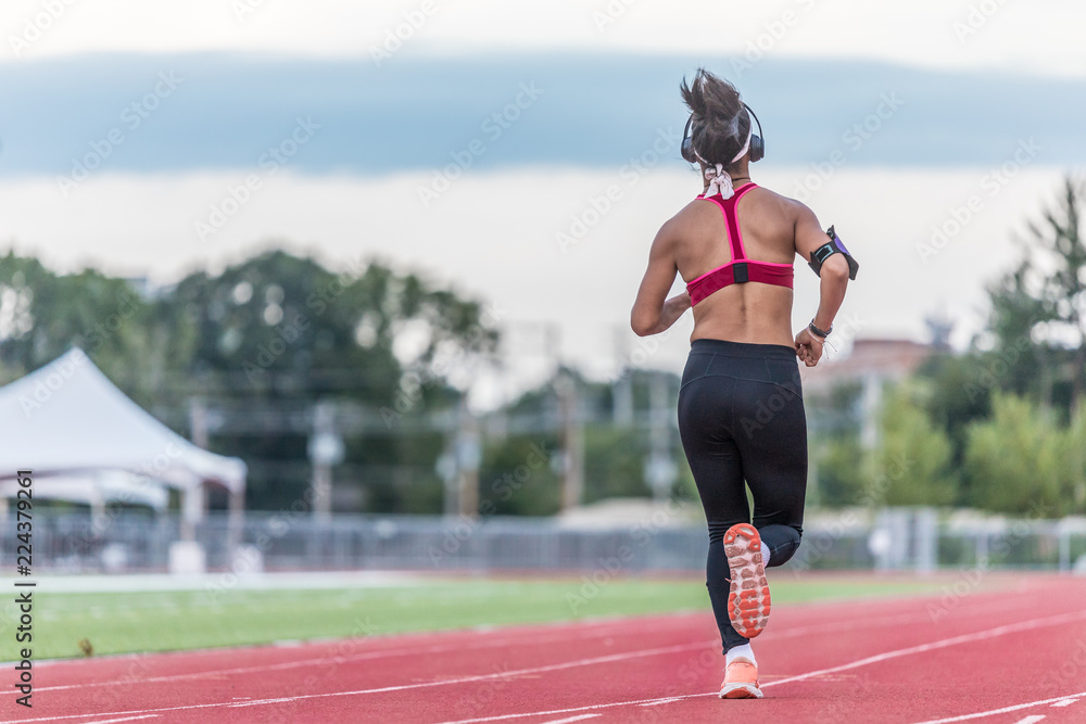 A young laddy in a black pant viewed from the back is running