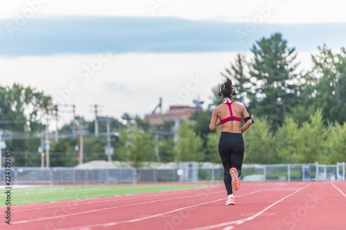 A young laddy in a black pant viewed from the back is running photo