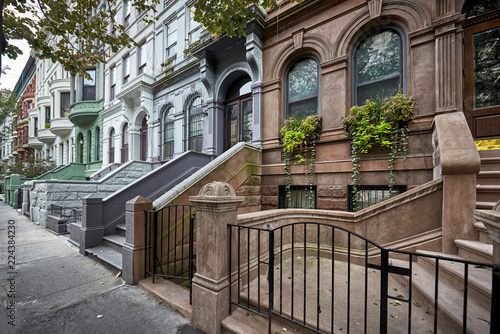 a row of colorful brownstone buildings in an iconic neighborhood  of Manhattan New York