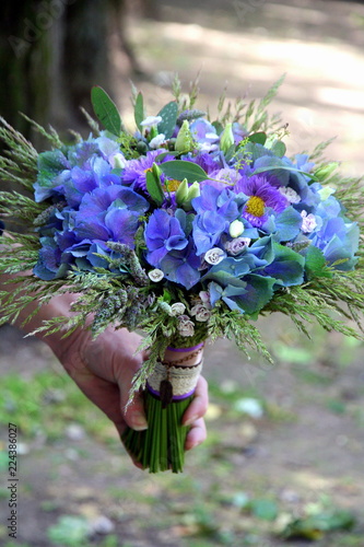 Presentation of a bouquet in hand against the background of open space.