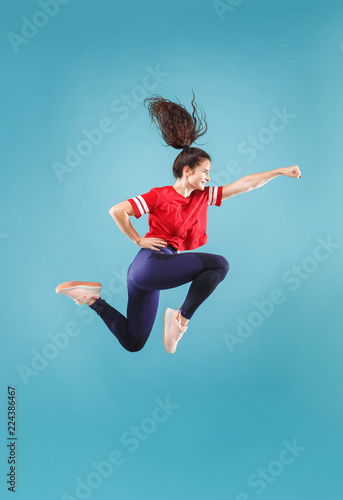 Fototapeta Naklejka Na Ścianę i Meble -  I am happy. Mid-air shot of pretty smiling young woman jumping and gesturing against pink studio background. Runnin girl in motion or movement. Human emotions and facial expressions concept