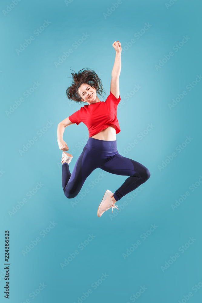 I am happy. Mid-air shot of pretty smiling young woman jumping and gesturing against pink studio background. Runnin girl in motion or movement. Human emotions and facial expressions concept I am happy. Mid-air shot of pretty smiling young woman jumping and gesturing against pink studio background. Runnin girl in motion or movement. Human emotions and facial expressions concept