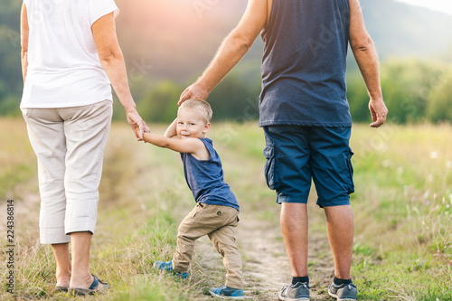 Happy grandparents on a walk with their grandchild