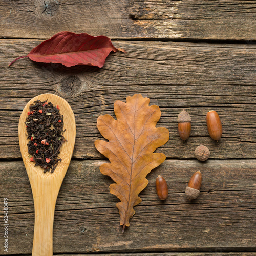 Cup of tea with autumn leaves on wooden background