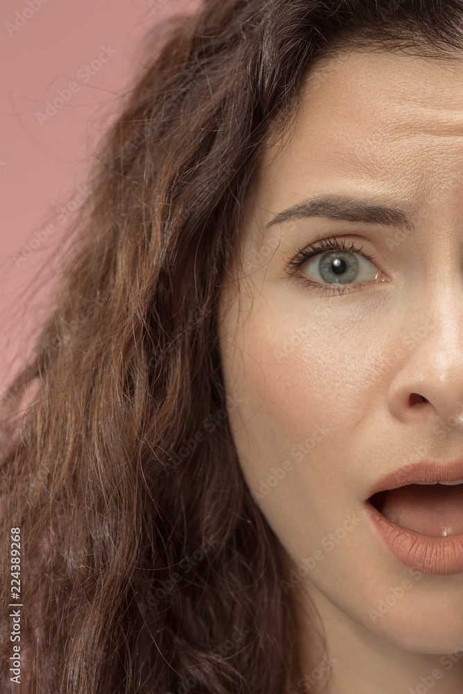 Why is that. Beautiful female half face portrait isolated on trendy pink studio backgroud. Young emotional frustrated and bewildered woman. Human emotions, facial expression concept. Why is that. Beautiful female half face portrait isolated on trendy pink studio backgroud. Young emotional frustrated and bewildered woman. Human emotions, facial expression concept.