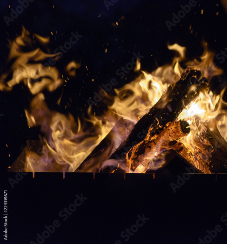 burning wooden logs in the fire at night