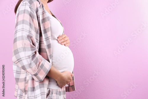 Pregnant woman posing on color background, closeup. Space for text