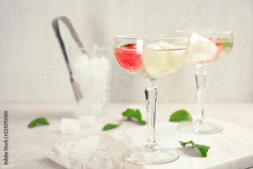 Glasses with tasty melon and watermelon ball drinks on light table