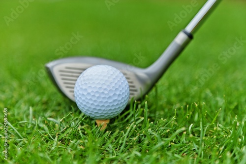 Golf Ball on Tee and Club on Golf Course