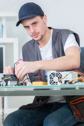 electronic engineer repairing electronic devices on broken computer photo