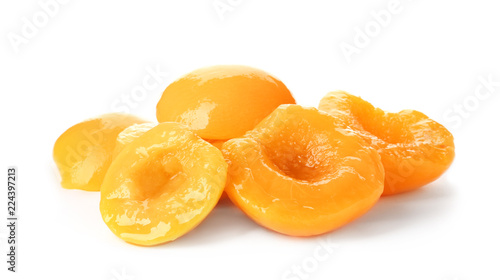 Halves of canned peaches on white background