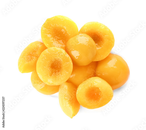 Halves of canned peaches on white background, top view