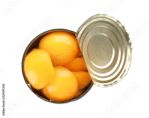 Tin can with conserved peach halves on white background, top view
