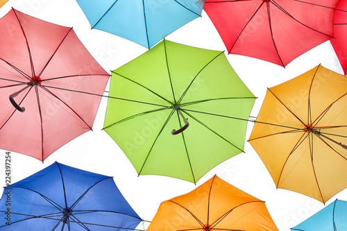 Many multicolored umbrellas on light background  bottom view