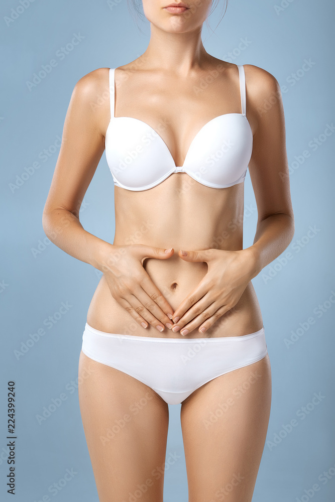 Health issues - female suffering from pain and holding her hands on the stomach Health issues - female suffering from pain and holding her hands on the stomach