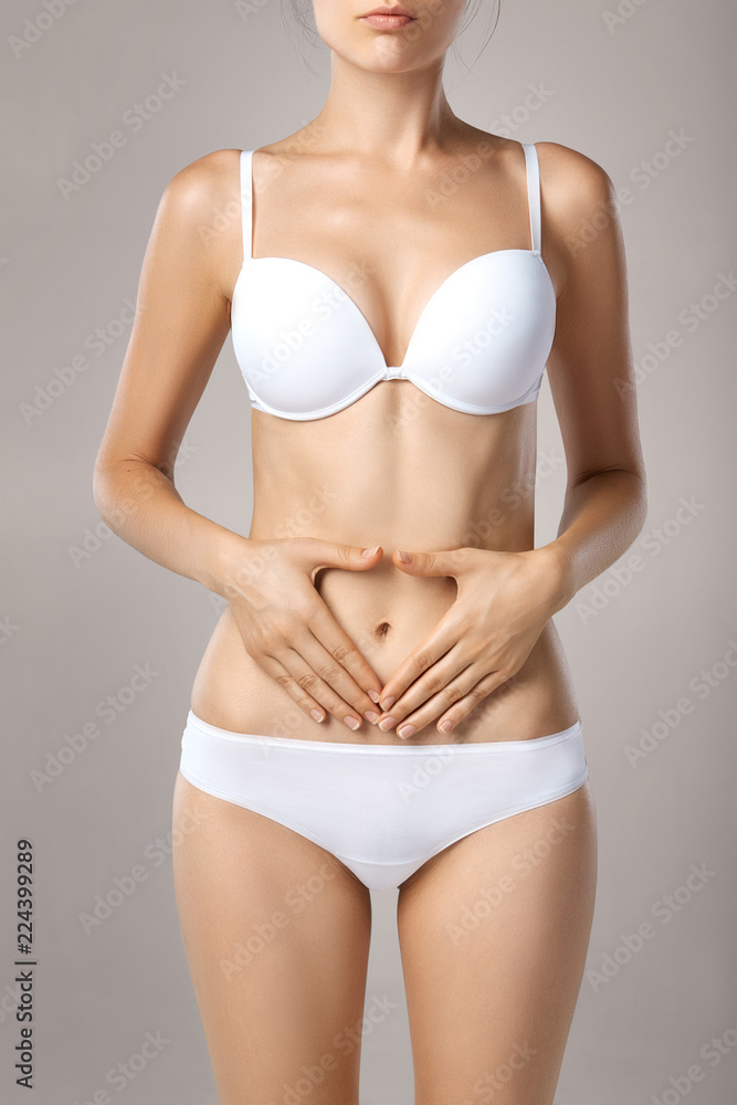 Health issues - female suffering from pain and holding her hands on the stomach