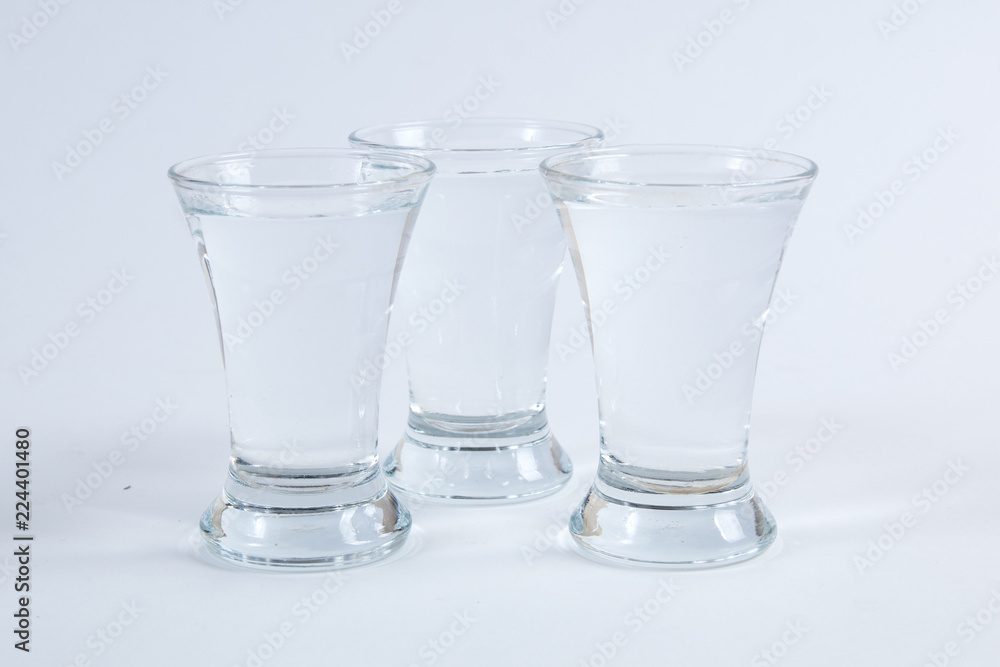 vodka in shot glasses on a white background vodka in shot glasses on a white background