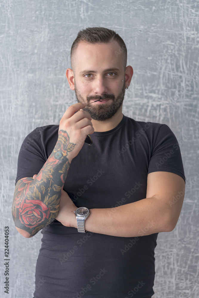 young businessman with tattoo, black t-shirt, beard and black hair, and  with a white background Stock Photo | Adobe Stock