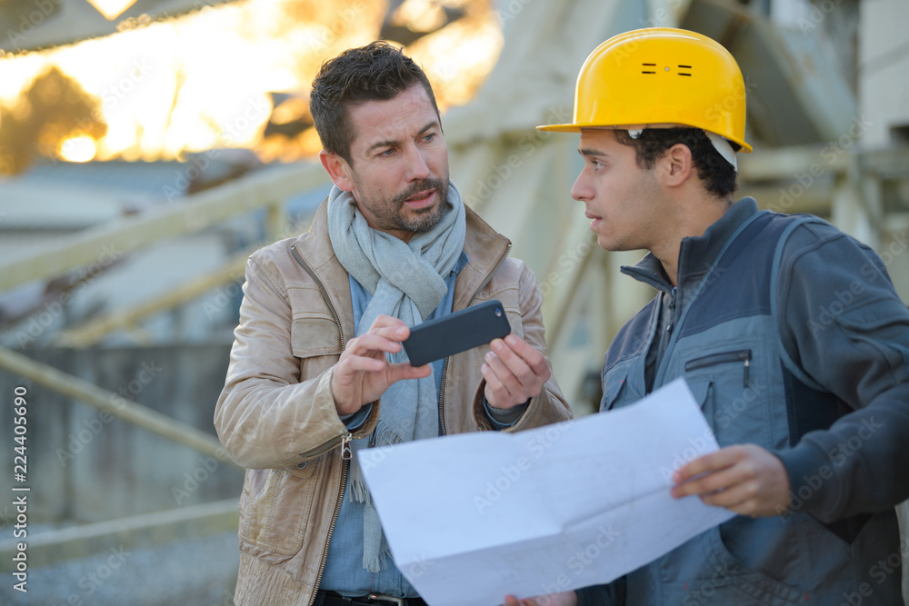 workers colleague looking at phone outdoors workers colleague looking at phone outdoors