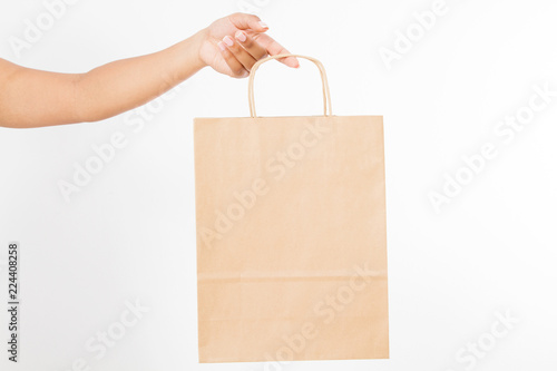 Template blank package. African american woman hand holding a paper kraft bag isolated on white background. Delivery and shopping concept.
