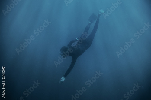 Fototapeta Naklejka Na Ścianę i Meble -  Man freediver wearing in wetsuit diving underwater.